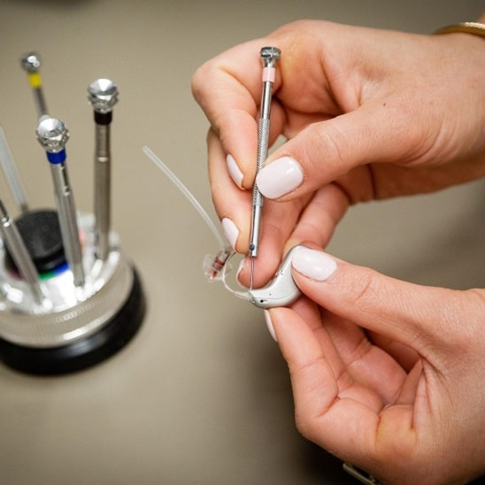 Entretien et réparation d'une aide auditive avec des outils spécialisés