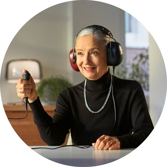 Un homme portant un casque audio tient un bouton poussoir pendant un test auditif.