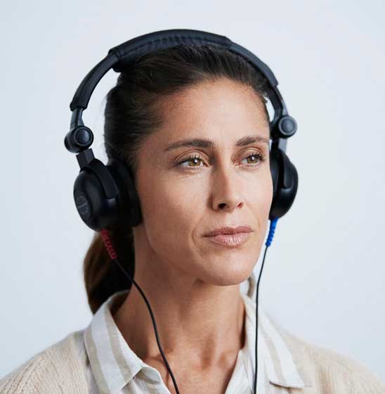Une femme portant un casque audio pour un test auditif.