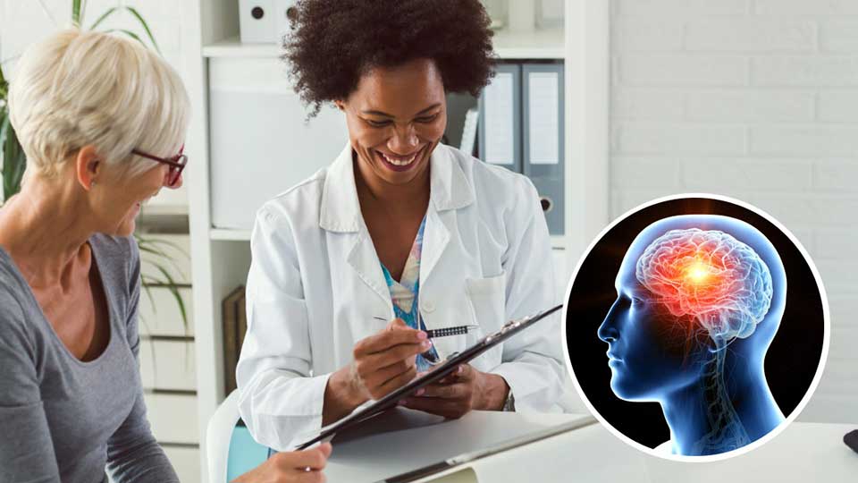 Una dottoressa in camice bianco consulta una paziente anziana in una clinica luminosa, con un'immagine laterale del cervello umano evidenziato nel contesto di un consulto medico.