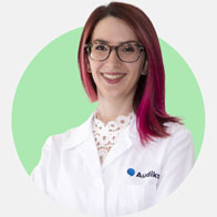 Simona Pucillo, audioprotesista presso Audika, con camice bianco e sfondo verde