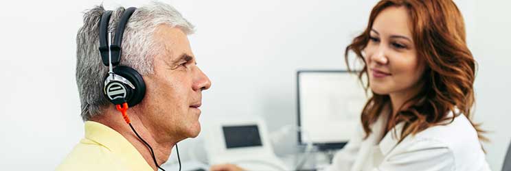 Test dell’udito condotto da un professionista dell’udito con un paziente che indossa cuffie.