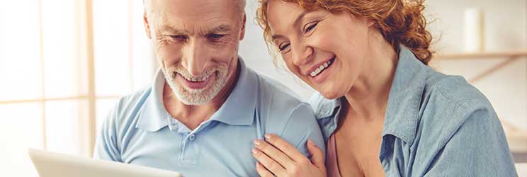 Donna dai capelli rossi appoggia la mano su un uomo sorridente.