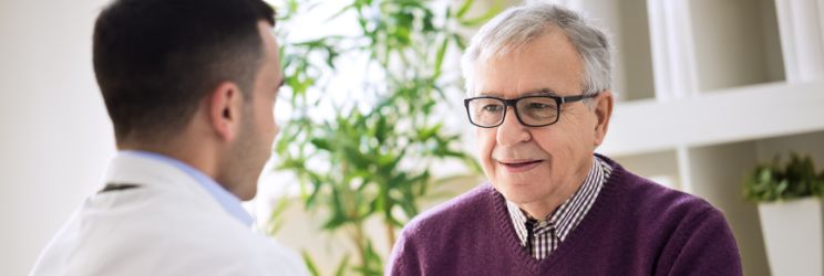 Uomo anziano che discute con un medico durante una consulenza sulla salute dell’udito