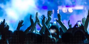 Mensen dansen en genieten van livemuziek tijdens een concert, met de nadruk op het belang van gehoorbescherming.