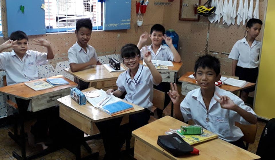 Kinderen in een klaslokaal in Vietnam met focus op gehoorondersteuning.