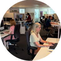 Medewerkers van het Audika contactcenter aan het werk op kantoor achter hun computers.