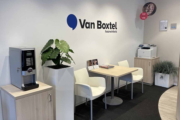 Wachtruimte bij Audika hoorzorgwinkel in Gemert met koffiemachine en informatiemateriaal.
