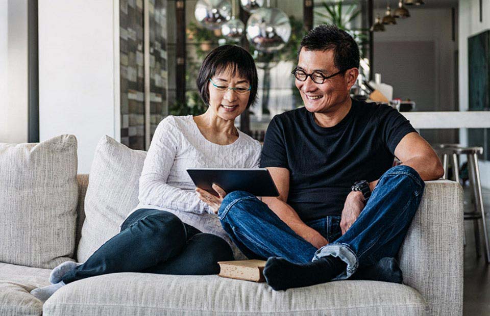 Afbeelding van een man en vrouw die op een tablet aan het kijken zijn