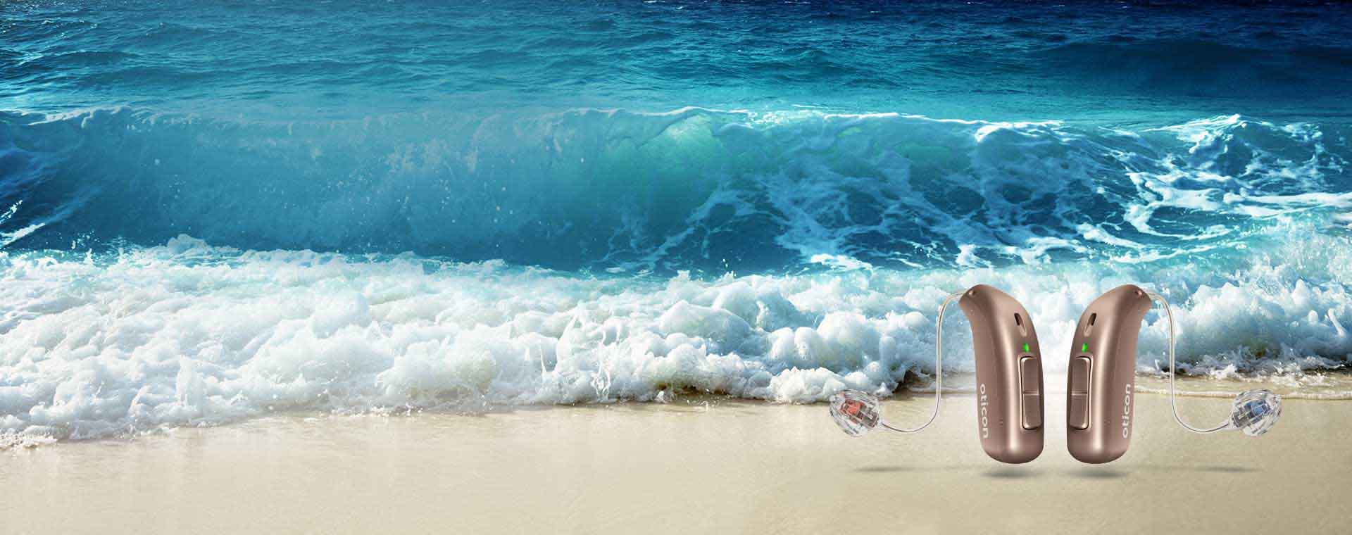 Hoortoestellen met tinnitusmaskeerder naast golven op een strand