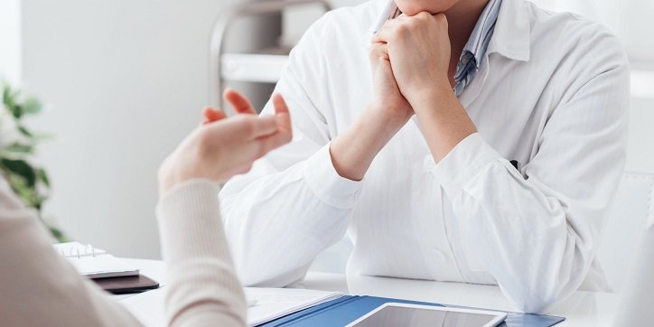 Lekarz specjalista od słuchu rozmawia z pacjentem w Centrum Medycznym Audika.