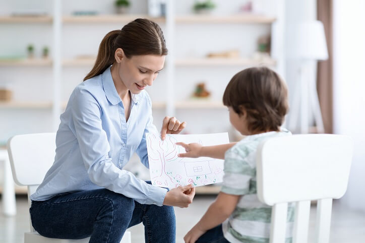 Kobieta przeprowadza u dziecka obiektywne badanie słuchu fonemowego metodą DFF.