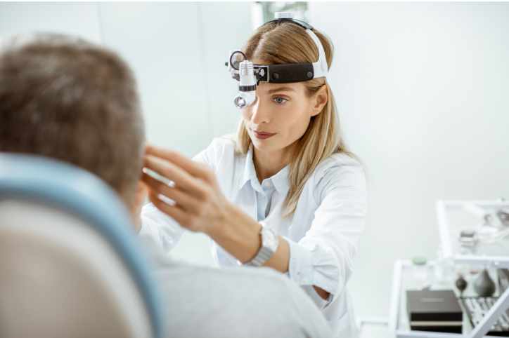 Kobieta przeprowadza endoskopowe badanie laryngologiczne. 