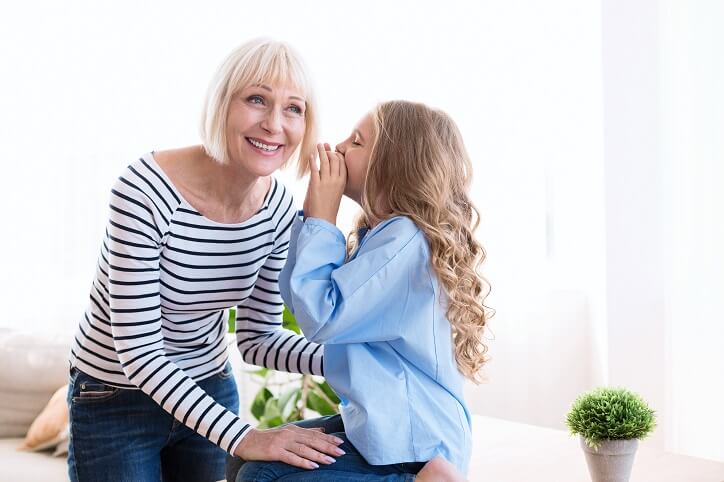Seniorka i młoda dziewczyna w intymnej rozmowie, ilustrujące znaczenie dobrej komunikacji dla relacji międzyludzkich.