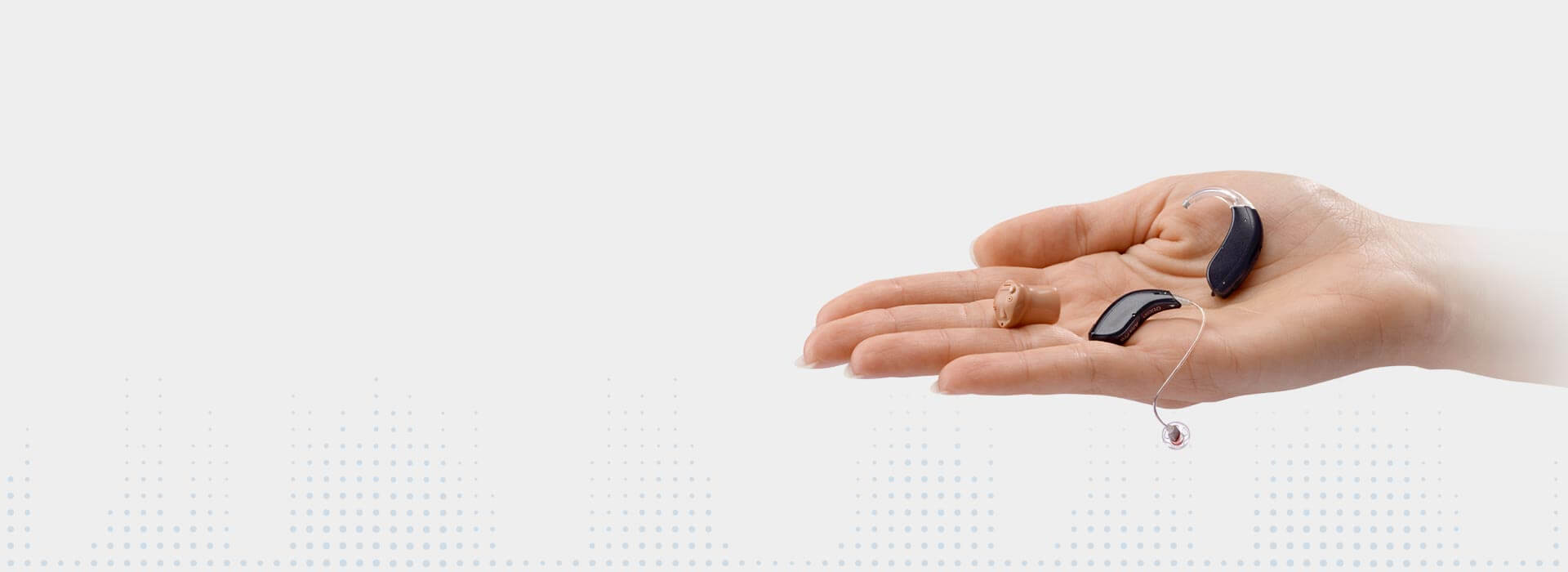 Na dłoni leży kilka rodzajów aparatów słuchowych (producent - Bernafon).