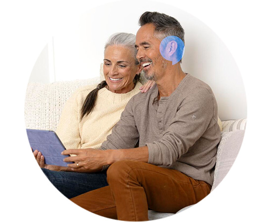 Para przeprowadza darmowe domowe badanie słuchu, korzystając z tabletu na kanapie.