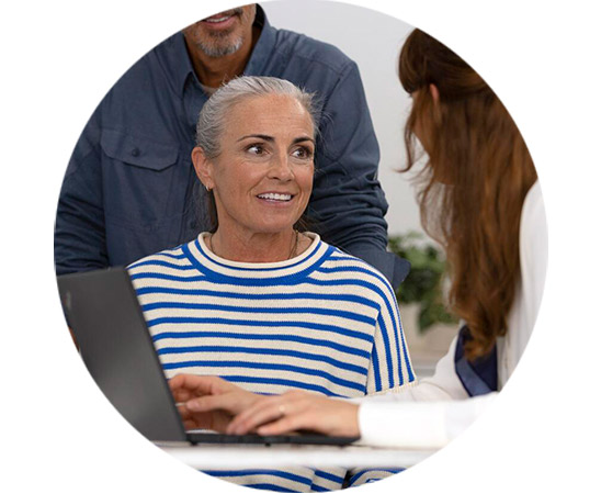 Kobieta omawia wyniki badania słuchu z protetykiem w nowoczesnym gabinecie.