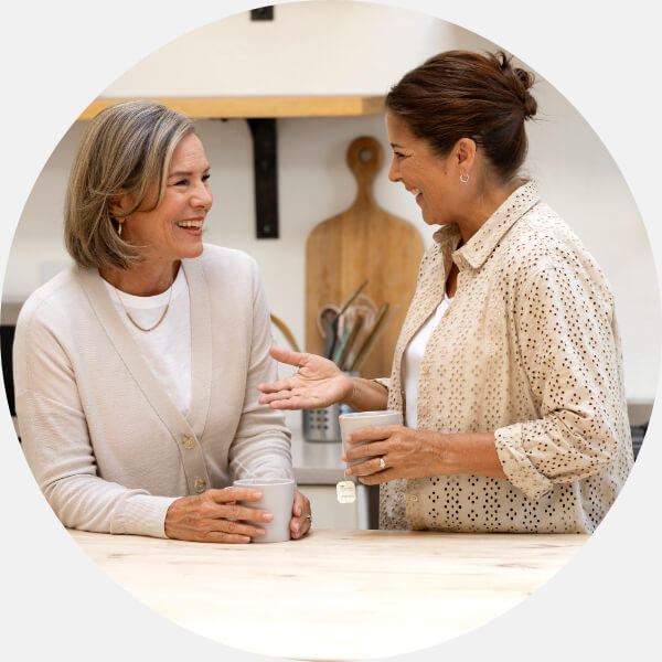 Image shows audiologist talking to woman in a hearing clinic