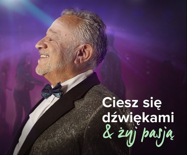 Starszy mężczyzna w eleganckim smokingu z muszką stoi na tle rozmytego parkietu tanecznego o fioletowym oświetleniu. Tekst: „Ciesz się dźwiękami & żyj pasją”.