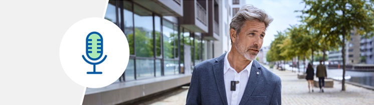 Akcesoria Oticon Intent™ – mikrofon bezprzewodowy Oticon ConnectClip™ na tle nowoczesnej architektury.