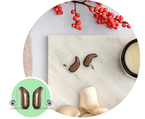 Nowoczesne aparaty słuchowe zauszne Oticon Intent™ na tle dekoracyjnym.