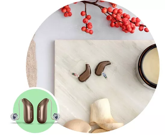 Nowoczesne aparaty słuchowe zauszne Oticon Intent™ na tle dekoracyjnym.