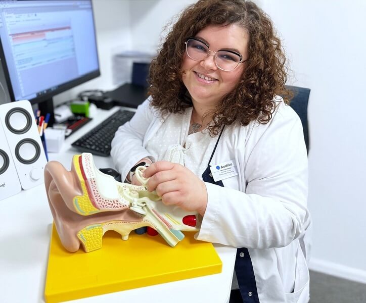 Protetyk słuchu Aldona Słowińska prezentuje model ucha w swoim gabinecie.