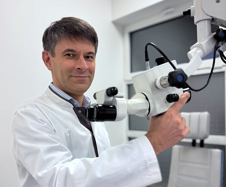 Lekarz laryngolog Marek Zadrożniak korzystający z nowoczesnego sprzętu diagnostycznego w gabinecie.