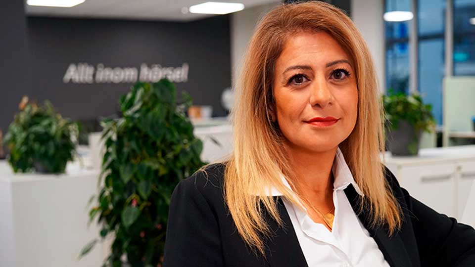  Audikas VD i modern kontorsmiljö med sloganen ’Allt inom hörsel’ i bakgrunden.