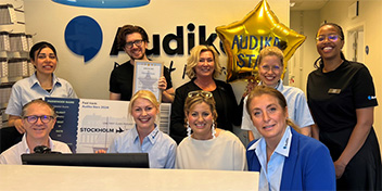 Bild på en Audika star tillsammans med sitt team på klinik