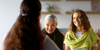  Två kvinnor sitter mitt emot en audionom på Audikas nya hörselklinik i Jönköping.