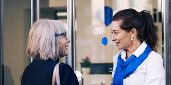  En audionom välkomnar en kund vid ingången till Audikas hörselklinik i Gävle.