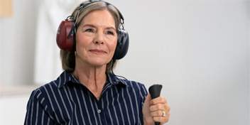 Kvinna som gör hörseltest hos Audika