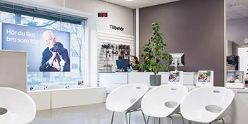  En av Audikas hörselkliniker med väntrum, reception och skylt som frågar: ’Hör du lika bra som förr?’.