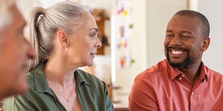  Tre personer i samtal, där varje person har olika typer av hörselnedsättning.