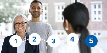  Två besökare på Audikas hörselklinik pratar med en audionom.