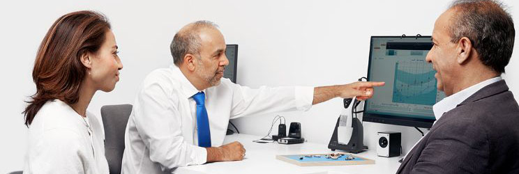 Bild på audionom och människor som pratar om resultat av gratis online hörseltest.