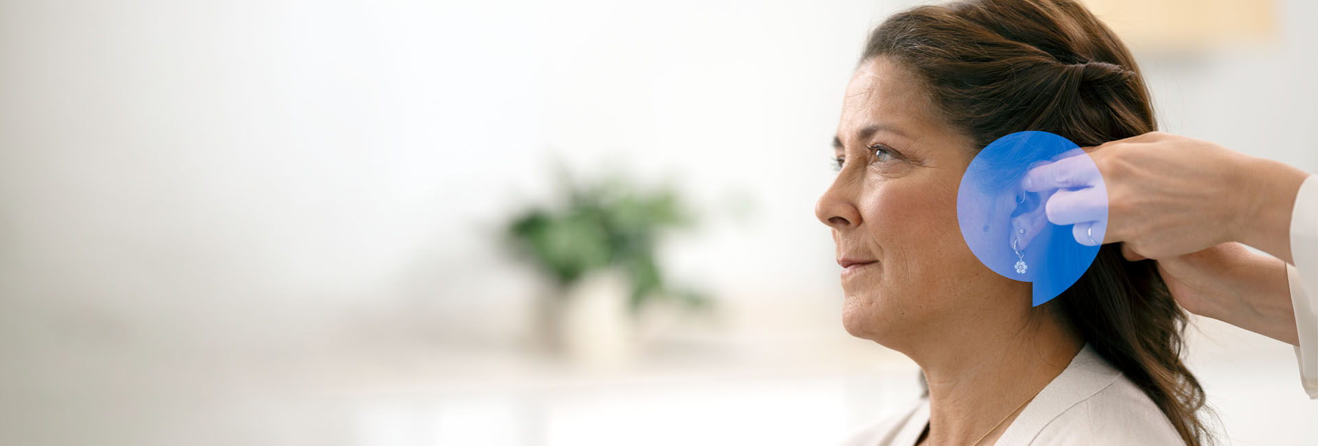 En kvinna som använder hörapparater som hon provat ut hos Audika