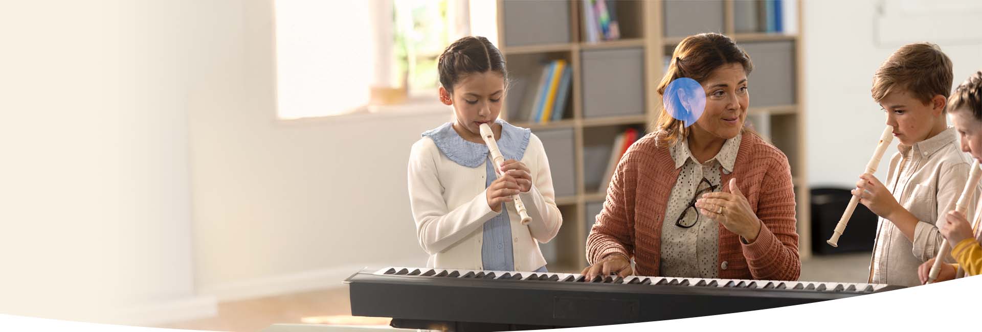 Lärare som spelar piano med elever som spelar flöjt