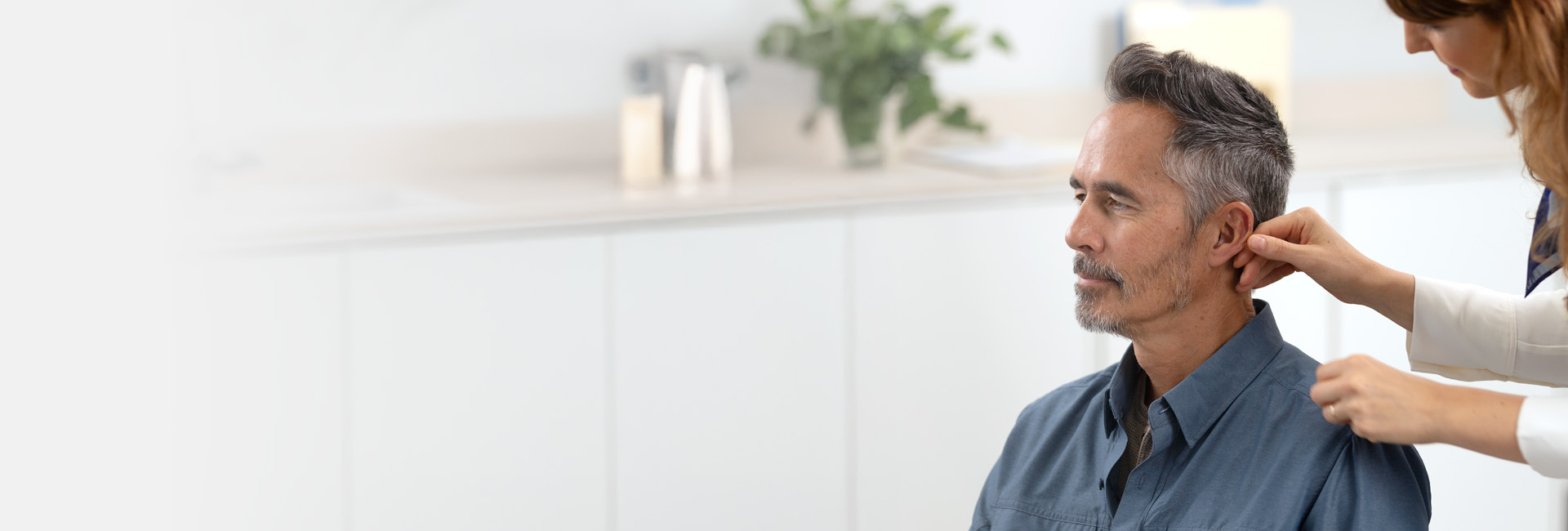Man som testar en hörapparat på en av Audikas hörselkliniker i Skåne