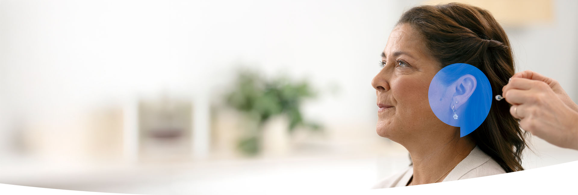 Kvinna som testar den senaste hörapparatstekniken hos Audika