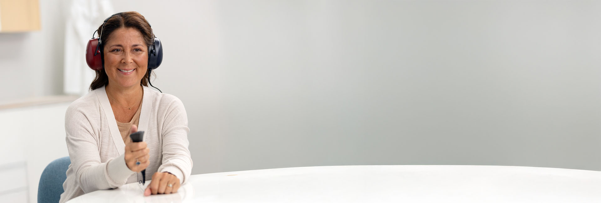 Bild på en kvinna som gör ett hörseltest som visar på konduktiv hörselnedsättning