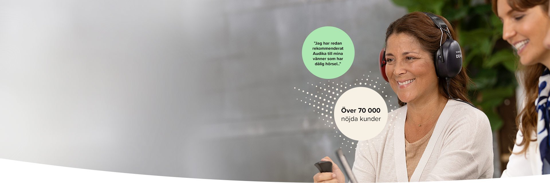 Kvinna genomför hörseltest med hörlurar hos Audika, över 70 000 nöjda kunder visas i förgrunden.