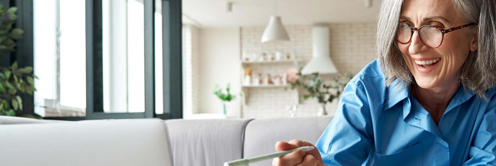  Kvinna får hjälp att justera sina hörapparater i hemmet.