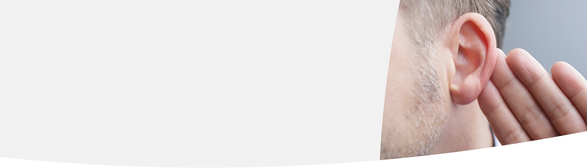  En man håller handen bakom örat för att höra bättre, ett möjligt tecken på tinnitus.