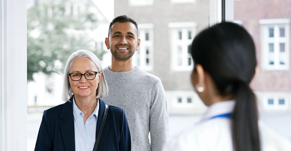  En man som hjälper sin mamma med att få vård för hennes hörselnedsättning.