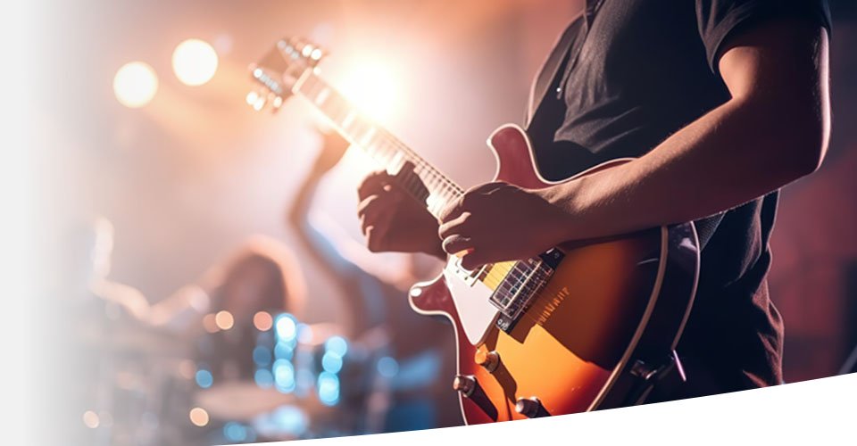  En kille spelar elgitarr på en konsertscen. Långvarig exponering för höga ljud, såsom musik på konserter, kan orsaka tinnitus.