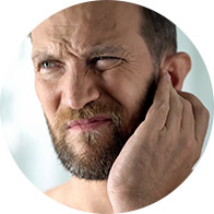 Bild på man som tar sig för örat som känner igentäppning i örat på grund av en konduktiv hörselnedsättning