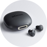  Oticon Own hörapparater bredvid ett laddningsetui.