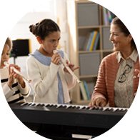  Lärare som använder arbetshjälpmedel till hörapparater anpassade hos Audika, hon spelar piano med barn i ett klassrum.